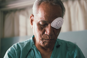 patient covering eye with protective shield after eyes cataract surgery in hospital - obrazy, fototapety, plakaty