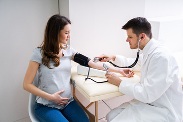 Doctor Measuring Blood Pressure Of Pregnant Woman