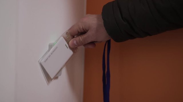 Close-up - the man put the card on checkpoint and open a door in building