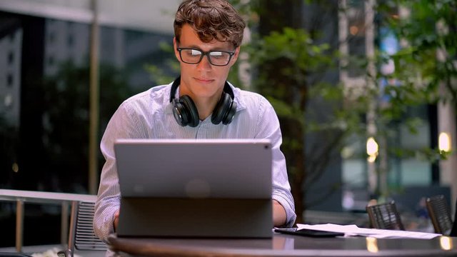 Professional financial expert checking account balance during distance job at modern digital tablet connected to 4g wireless, manager in spectacles reading text information from paper documents