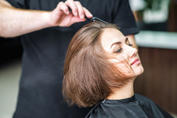 Naklejka premium Hairdresser combs hair.
