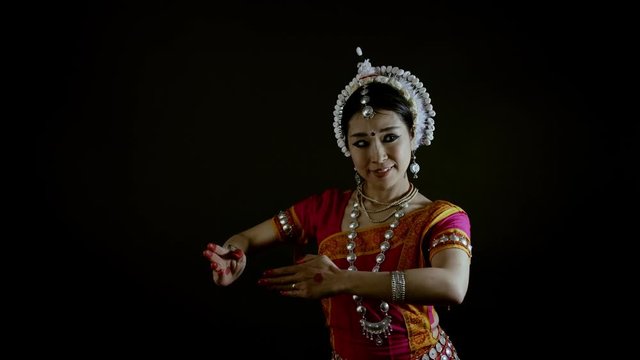 Female asian dancer perform Odissi Indian traditional dance, 4k studio shot on black backdrop 