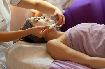 Obraz na płótnie Canvas Beautiful woman with facial mask at beauty salon