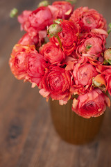 Elegance ranunculus bouquet on a wooden floor. Beautiful flowers composition in bright rosy colors. Perfectly for Birthday Celebration, Women's and Valentine's Day, Anniversary. Copy space. Top view.