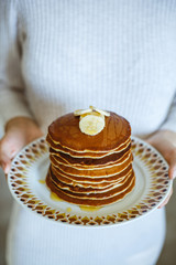 Pancakes prepared at home by young housewife. White background.