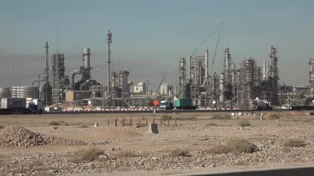 Trucks drive past oil refineries and petrochemical facilities in the Yanbu industrial zone in Saudi Arabia