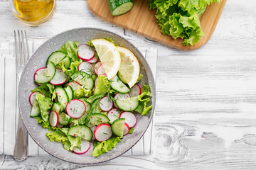 Vegetarian vegetable salad of radish, cucumbers, lettuce .  Healthy vegan food.