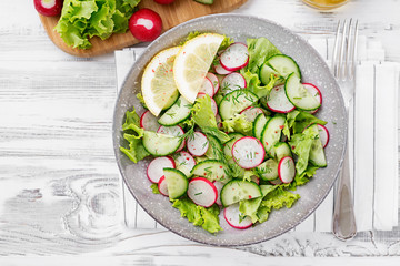 Vegetarian vegetable salad of radish, cucumbers, lettuce .  Healthy vegan food.