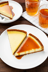 Cheesecake slices with caramel sauce on white plate. Slices of classic cheesecake. 