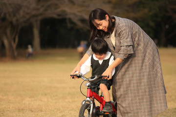 Fototapeta na wymiar 自転車に乗る練習をする親子