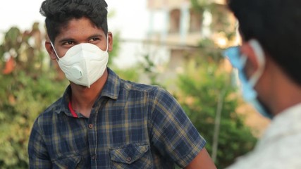 Shoulder shot, Two People with medical face mask at public park talking, with Social Distancing to prevent coronavirus or covid-19 - Concept advice or avoiding close contact from covid 19 outbreak.