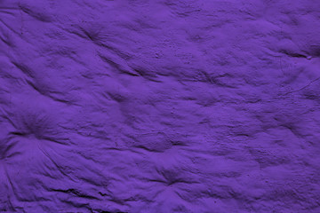 Background with crumpled dark purple surface. Smooth but uneven dark purple surface of the wall.