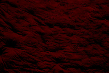 Rugged maroon surface with bulges and shadows. Maroon background with glare and dimming