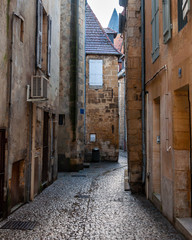 Fototapeta na wymiar Sarlat in Aquitaine, France. The capital of Périgord Noir, a medieval village full of picturesque alleys and monuments. View of a typical alley in the historic center.