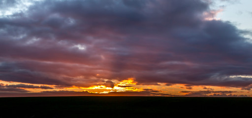 Dramatic sunset with the sun just above the ground..