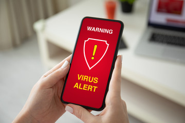 female hands holding phone with warning virus alert alarm