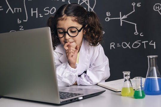 little scientist girl looking to the computer
