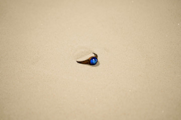 Fototapeta na wymiar old ring lies in the sand