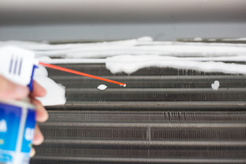 Technician man hand cleaning air condition filter with chemical foam