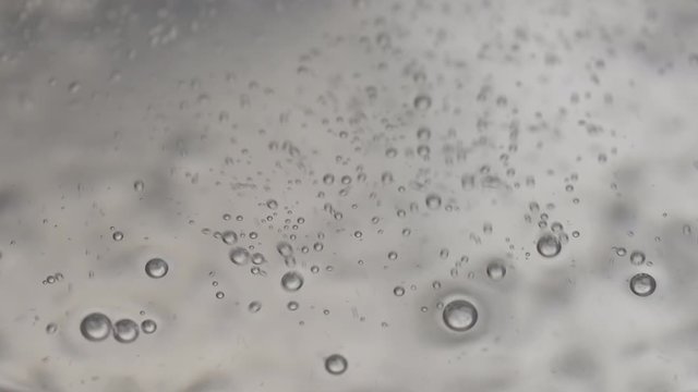 Macro close-up shot of boiling water process. Close-up of steamy water with bubbles in transparent pot