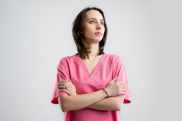 Fototapeta premium Young woman medical professional nurse or doctor dressed with pink hospital clothes looking confident hero-shot