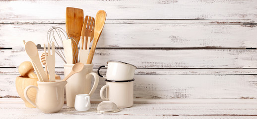 Baking kitchenware and baking products on white wooden background.