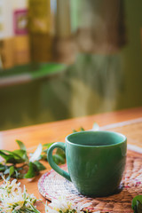 Steam of morning tea on table decorated with spring flowers