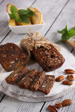 Healthy food. Sliced dark bread on a light wooden board. Bread made from green buckwheat, nuts, honey, dried fruits. Rustic. Background image, copy space