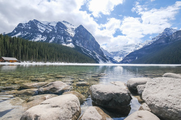 Fototapeta premium Mount fairview, partly frozen lake, rocks in foreground. Lake Louise Banff National Park, Alberta Canada
