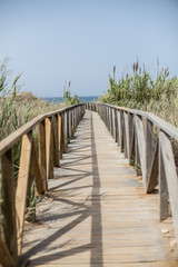 puente de madera que hace de pasarela al mar mediterráneo