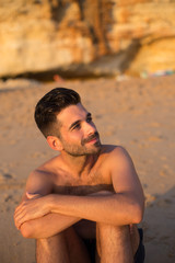 Fototapeta na wymiar Retrato de hombre guapo joven en la playa Durante el atardecer 