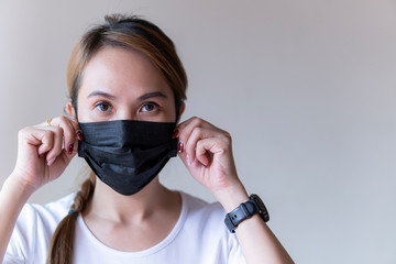 Asia woman wearing a black face mask to deal with virus or pollution.