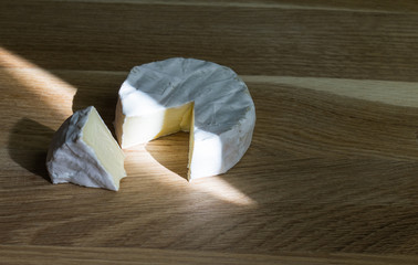 Beautiful White Round of Soft Cheese on a Wooden Table
