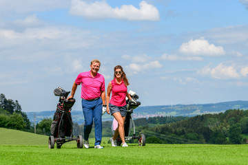 Paar gutgelaunt unterwegs auf einem Golfplatz
