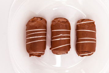 Top view of a chocolate cake with white icing. The treat is on a white plate