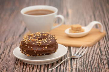 Dessert, Donuts, chocolate and strawberry circles, sugar and cream on Donuts and hot coffee cups, preparation for a break or party on the wooden table background.