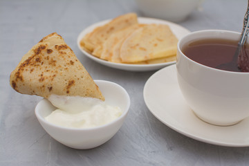 Homemade, thin, Russian pancakes with sour cream for breakfast.