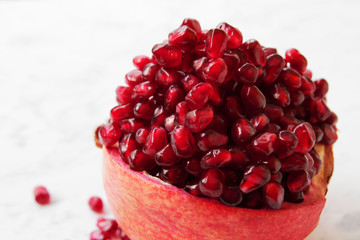  beautifully chopped pomegranate and its seeds, aesthetically laid out on a marble table.