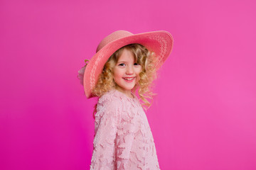 little girl in her mother's big shoes, dress, hat, and shopping bags. baby girl smiling and holding bags from the store. little fashionista on a shopping trip