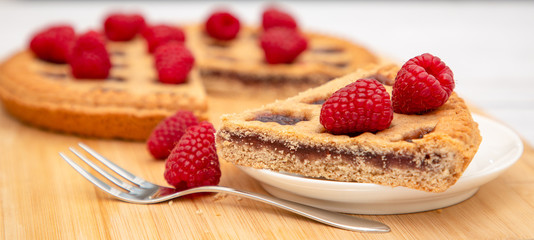 Dessert Raspberry Pie cake with strawberry or Fruit in a round bread for Break time or a party shot at the top view and copy space on a white wooden table.
