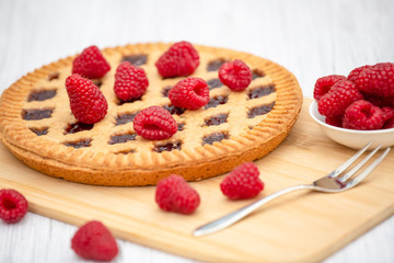Dessert Raspberry Pie cake with strawberry or Fruit in a round bread for Break time or a party shot at the top view and copy space on a white wooden table.
