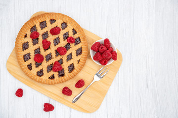 Dessert Raspberry Pie cake with strawberry or Fruit in a round bread for Break time or a party shot at the top view and copy space on a white wooden table.