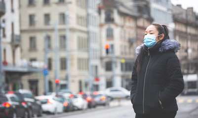The image face of a young Asian woman wearing a mask to prevent germs, toxic fumes, and dust. Prevention of bacterial infection in the air around the streets and gardens.
