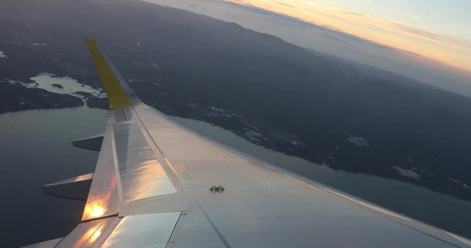 View of the island of Cebu in the Philippines from a plane ascending just after take off with the sun low in the horizon as it sets.