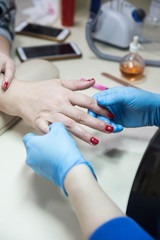 Obraz na płótnie Canvas Nail care and manicure. Closeup woman hands in a beauty salon receiving a manicure and hands spa massage by a beautician master.