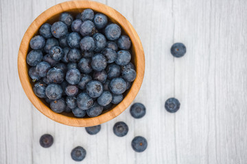 Bio Fruit Blueberry in bowl wood health and diet with vitamin c in close-up on the wood table.
