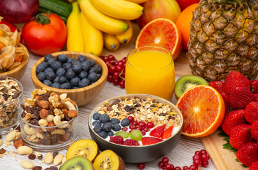 Group Fruits Breakfast mixed vegetables with salad bowl, nuts bowl, strawberry, banana, and pineapple, orange juice,  vitamin c in food  nature for health and diet in the top view on the wood table.