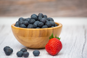 Bio Fruit Blueberry in bowl wood health and diet with vitamin c in close-up on the wood table.