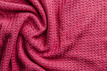 Fototapeta na wymiar Pink wool knitted fabric texture. Wrinkled background of fabric.