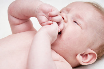 Cute Baby sucks fingers and cries. Close up